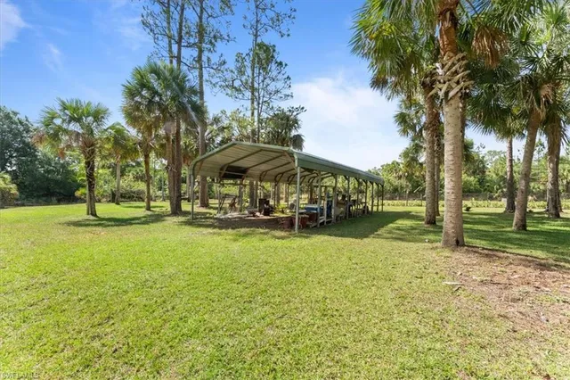 a yellow house with a big yard and large trees