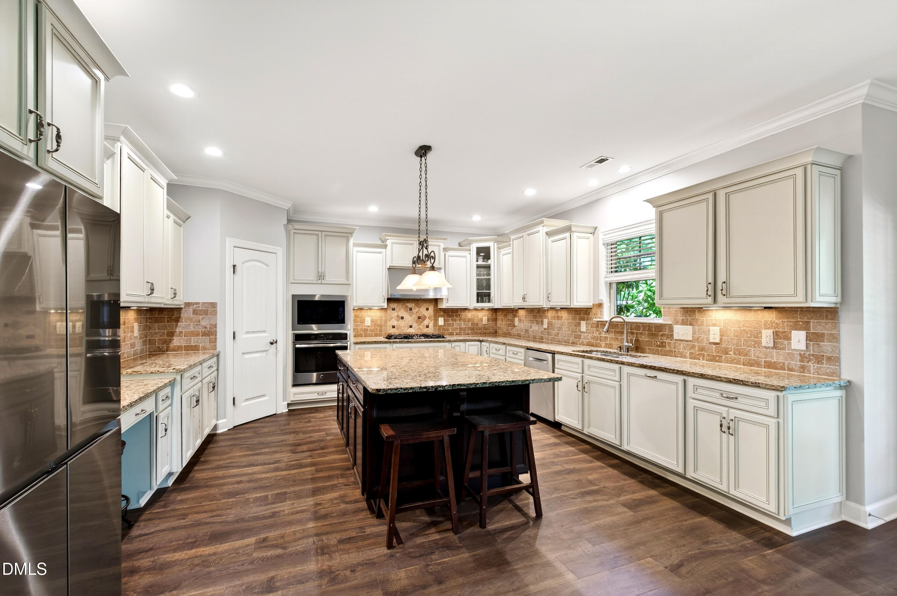313 Karpen Lane Cary, NC 27519 - Photo 26 of 86 a kitchen with stainless steel appliances kitchen island granite countertop a table chairs sink and cabinets