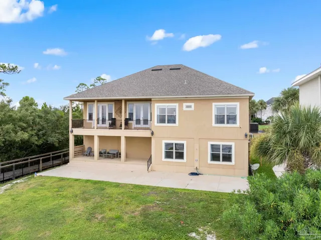 a front view of a house with a yard and potted plants