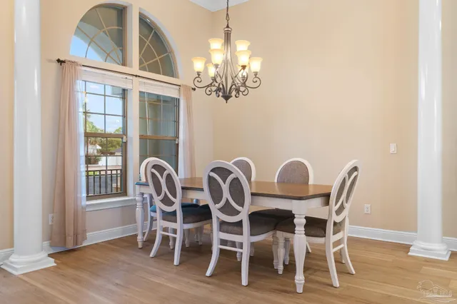 a view of a dining room with furniture a chandelier and wooden floor