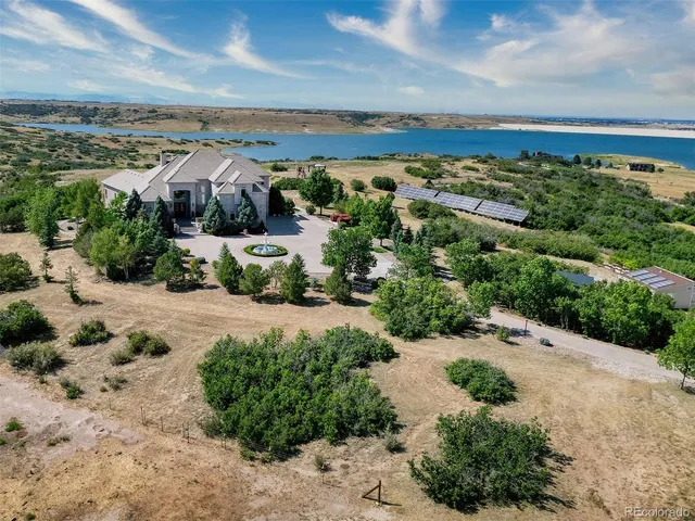 a front view of a house with a yard and potted plants