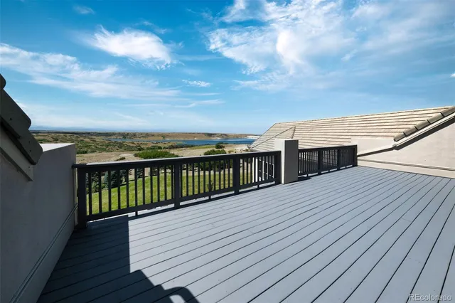 a view of a dining room with furniture a chandelier and large windows