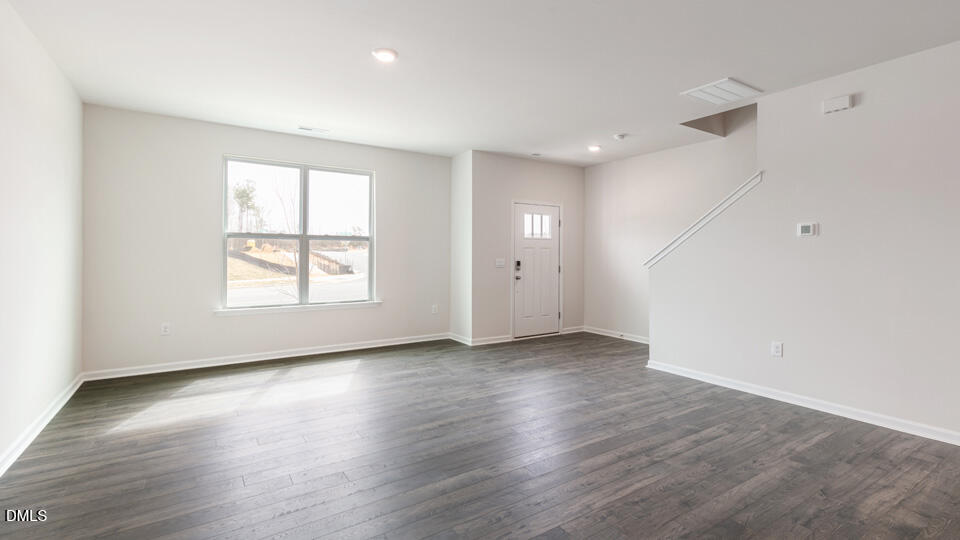 910 Sculptor Street Wendell, NC 27591 - Photo 6 of 44 an empty room with wooden floor and windows