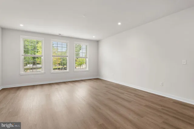 an empty room with wooden floor and window