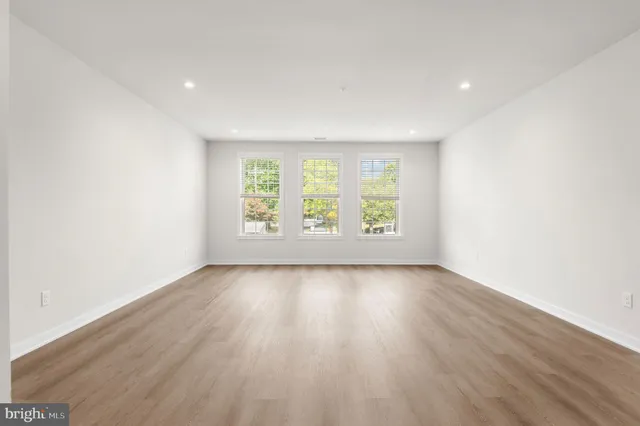 an empty room with wooden floor and bathroom