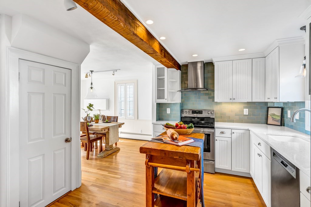 396 Plainfield Road, Unit 396 Concord, MA 01742 - Photo 13 of 24 a kitchen with stainless steel appliances granite countertop a stove top oven a sink dishwasher and white cabinets with wooden floor