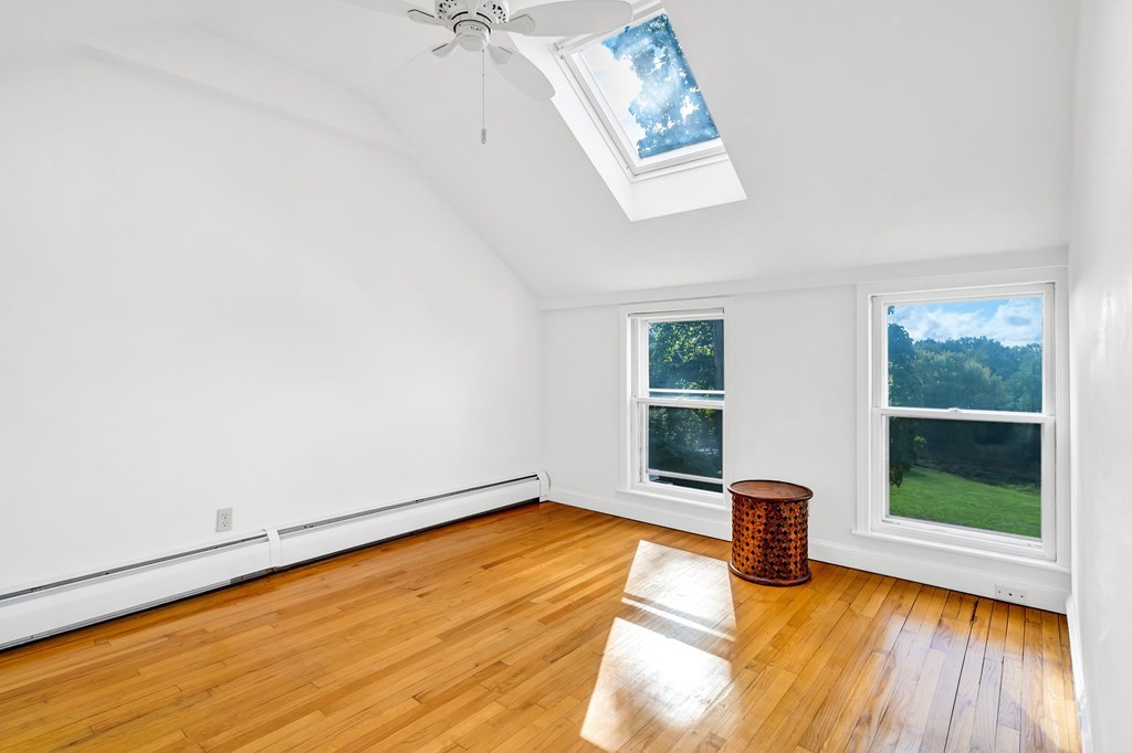 396 Plainfield Road, Unit 396 Concord, MA 01742 - Photo 20 of 24 a view of an empty room with a window and wooden floor