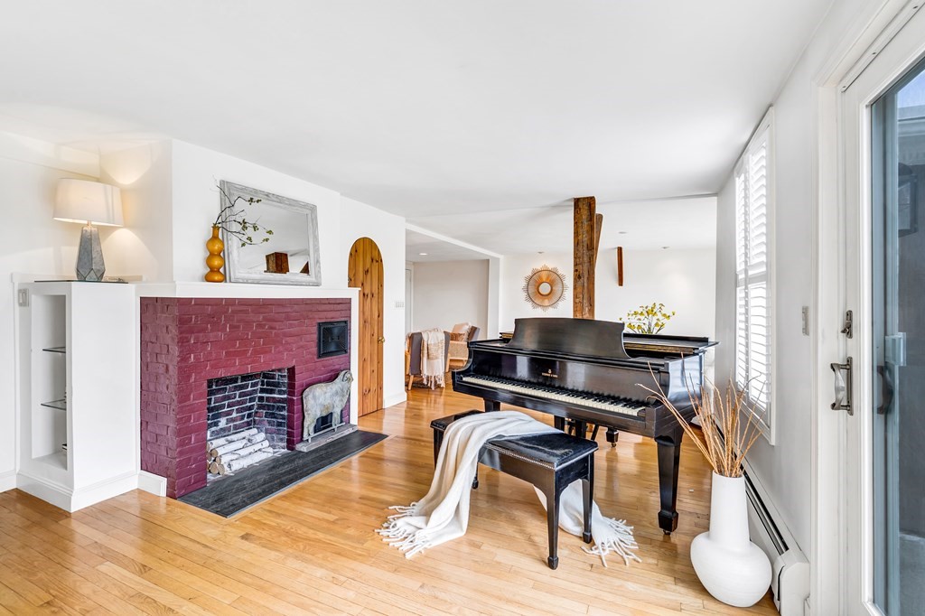 396 Plainfield Road, Unit 396 Concord, MA 01742 - Photo 5 of 24 a living room with furniture a fireplace and paintings on the wall