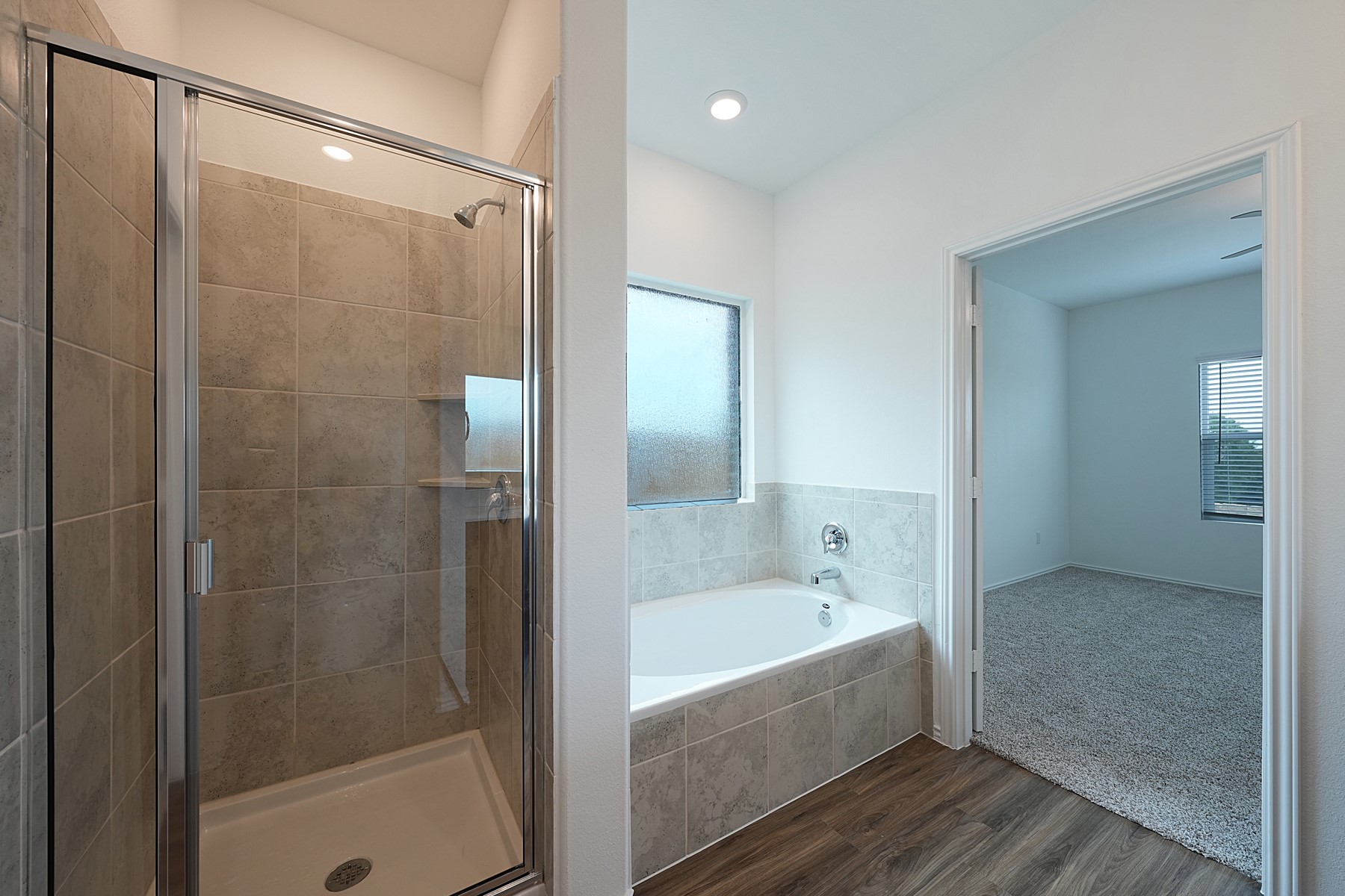 932 Mallow Road Leander, TX 78641 - Photo 17 of 34 Indulge in a primary bath featuring a spacious soaking tub and a dedicated shower with a glass enclosure.