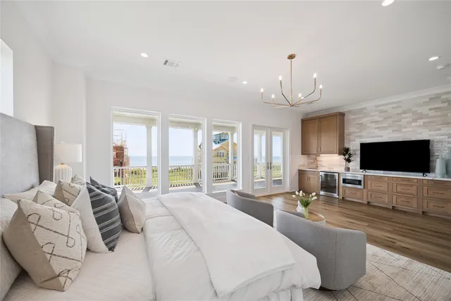 a spacious bedroom with a bed and a flat screen tv