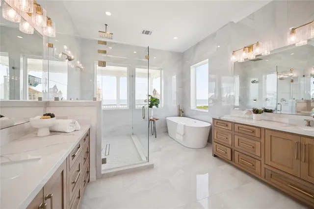 a bathroom with a double vanity sink a bathtub and next to a window