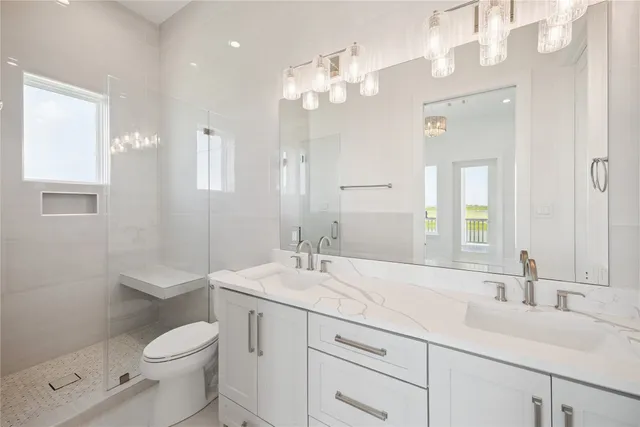 a bathroom with a double vanity sink toilet and a mirror