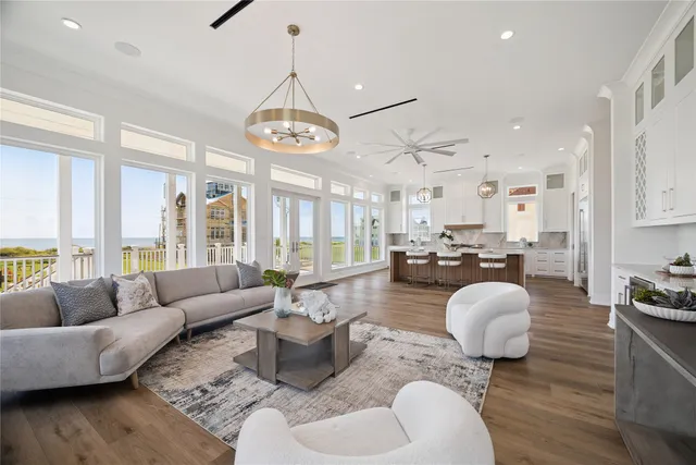 a living room with furniture kitchen view and a large window