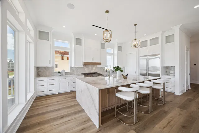 a large kitchen with kitchen island a sink table and chairs