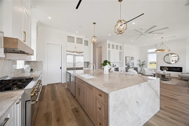 a kitchen with stainless steel appliances kitchen island granite countertop a stove a sink and a wooden cabinets