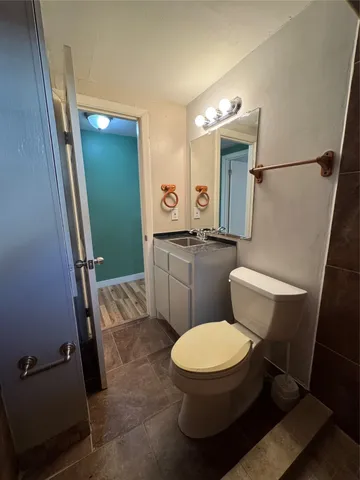 an empty room with wooden floor chandelier fan and windows