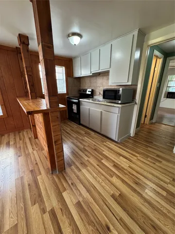 a kitchen with sink a refrigerator and wooden floor