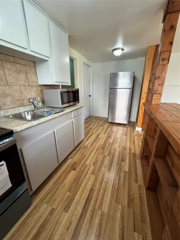 a kitchen with a sink and wooden floor