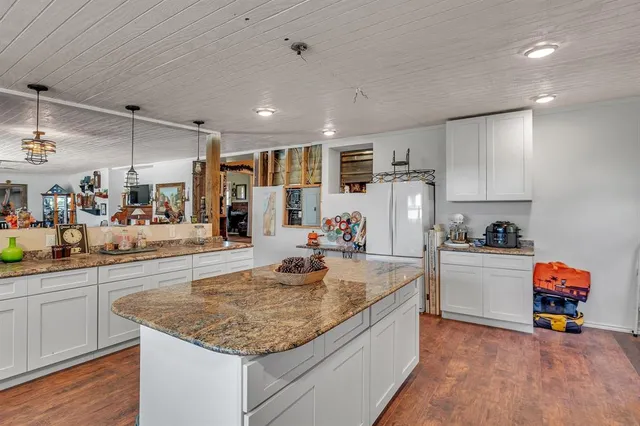 a kitchen with stainless steel appliances granite countertop a sink dishwasher and a stove with wooden floor