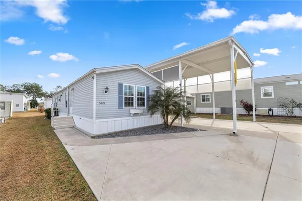 a view of a house with backyard and a patio