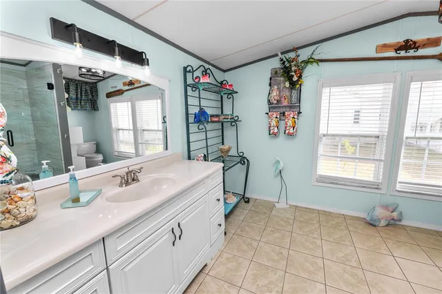 a bathroom with a granite countertop sink mirror vanity and toilet