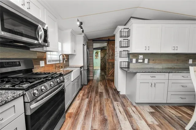 a kitchen with stainless steel appliances a stove microwave and a refrigerator