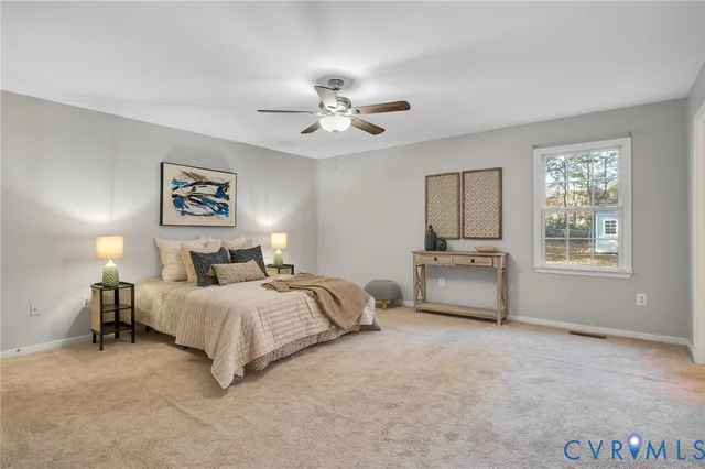 a spacious bedroom with a bed a chandelier and a window