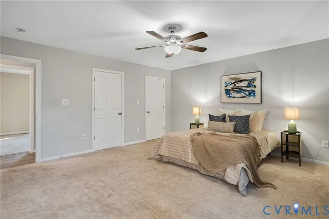 a spacious bedroom that has a bed and a chandelier