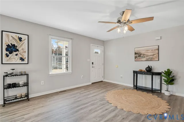 a view of an empty room with a window and wooden floor