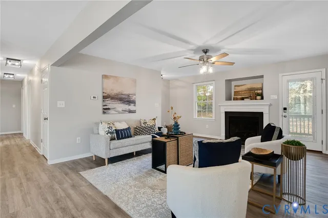 a living room with furniture a fireplace and a chandelier