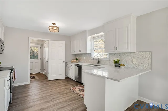 a kitchen with a sink cabinets and wooden floor