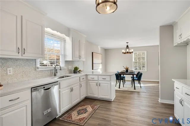 a kitchen with white cabinets and wooden floor