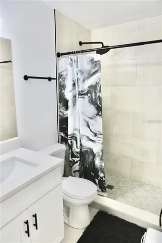 a bathroom with a shower toilet and sink