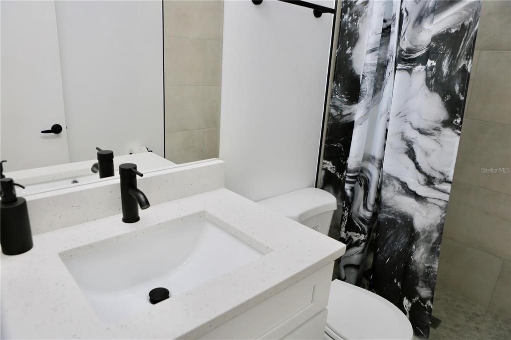 3308 Southwest 26 Way, Unit B Gainesville, FL 32608 - Photo 16 of 23 a bathroom with a sink a toilet and a tub