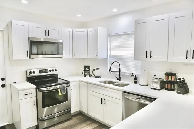 a kitchen with cabinets stainless steel appliances and a sink