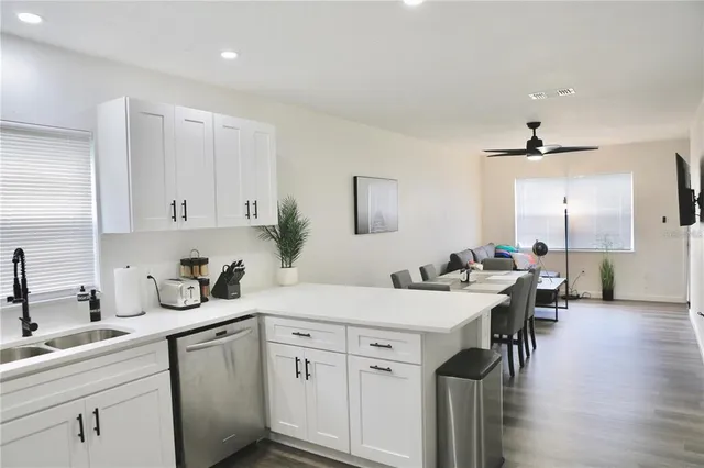 a kitchen with a sink cabinets and wooden floor