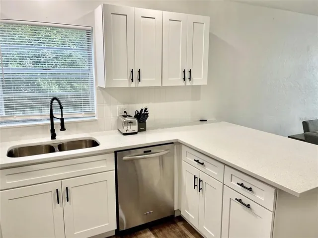 a kitchen with white cabinets and white appliances