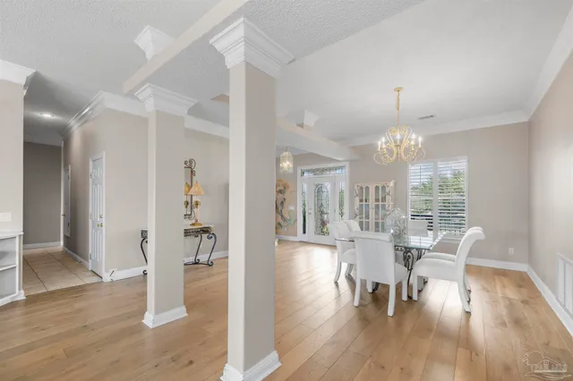 a dining room with furniture a chandelier and wooden floor