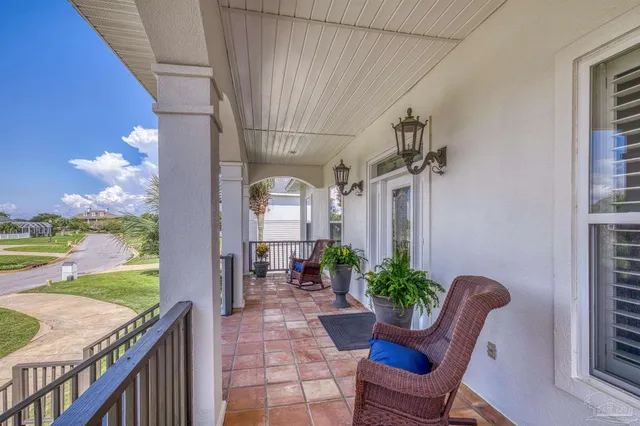 a view of a porch with chairs and potted plants