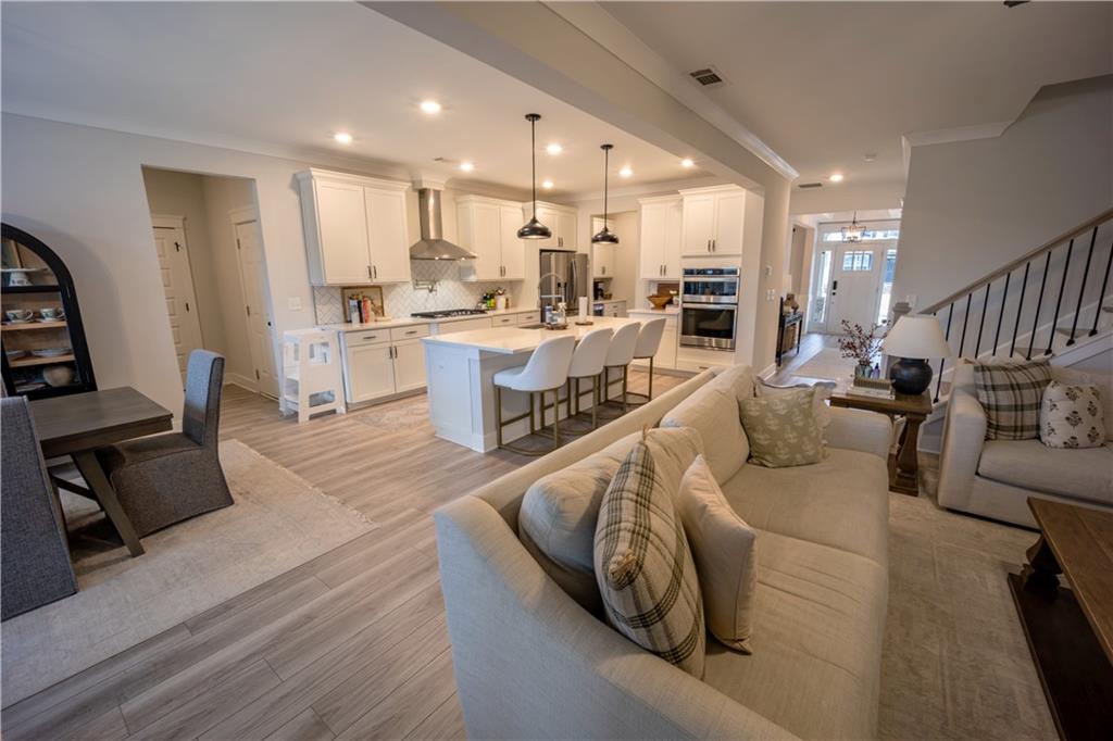 6833 Benjamin Drive Flowery Branch, GA 30542 - Photo 12 of 30 a living room with furniture and a dining table with wooden floor