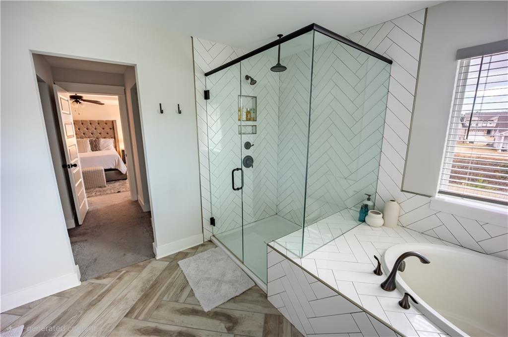 6833 Benjamin Drive Flowery Branch, GA 30542 - Photo 17 of 30 a bathroom with a tub a sink and a mirror