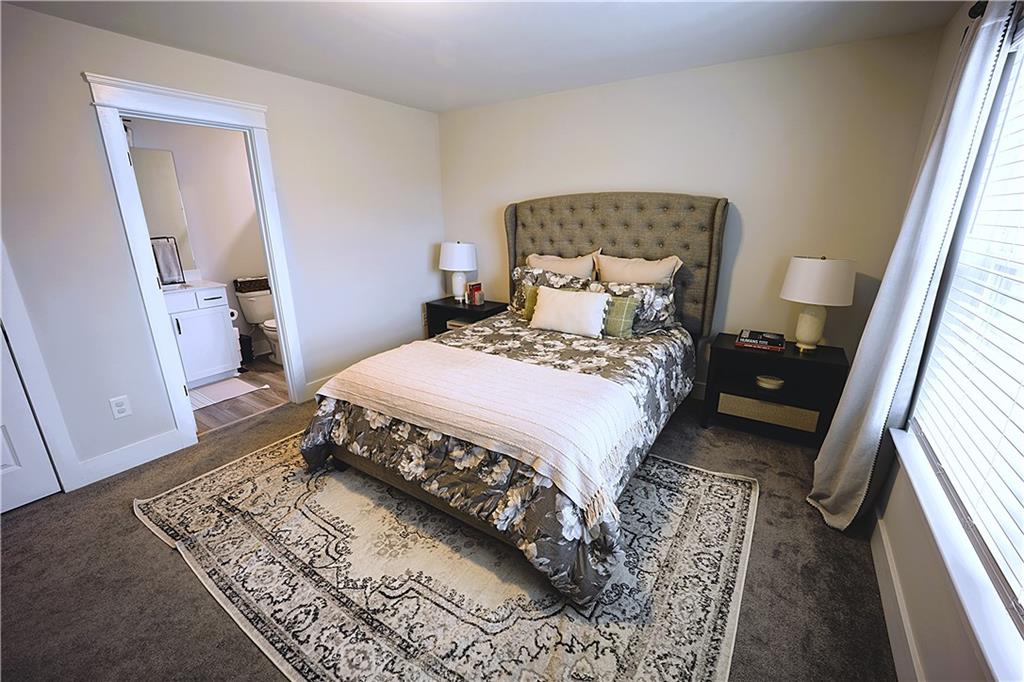 6833 Benjamin Drive Flowery Branch, GA 30542 - Photo 18 of 30 a bedroom with a bed wooden floor and a rug