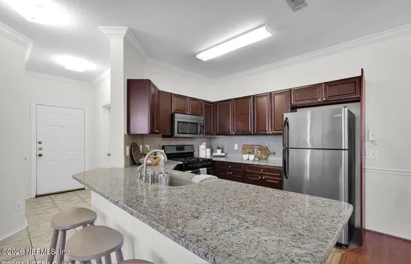 a kitchen with stainless steel appliances granite countertop a sink refrigerator and microwave