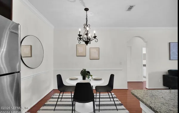 a dining room with furniture a potted plant and wooden floor