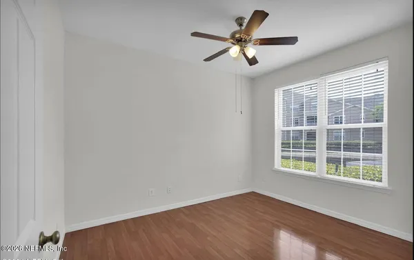 a view of a big room with wooden floor and windows