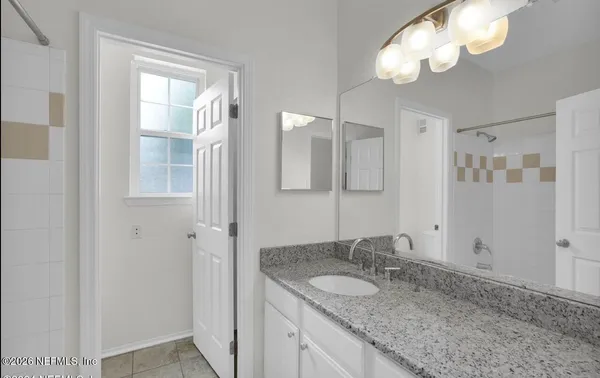 a bathroom with a granite countertop sink and a mirror