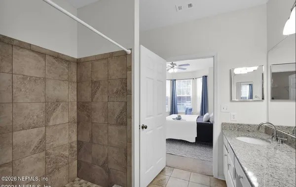 a bathroom with a granite countertop sink a toilet and shower