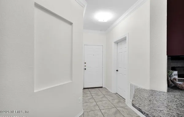 a view of a hallway to room with wooden floor