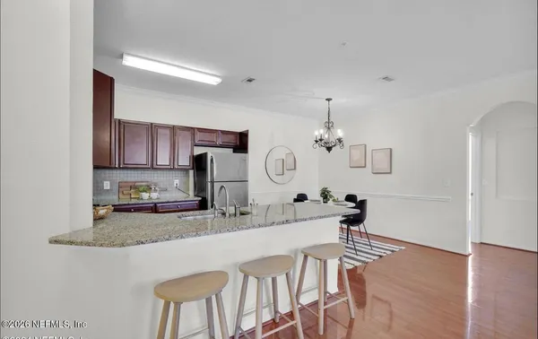 a kitchen with kitchen island granite countertop a sink and a refrigerator