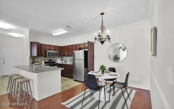 a dining room filled chandelier and kitchen view